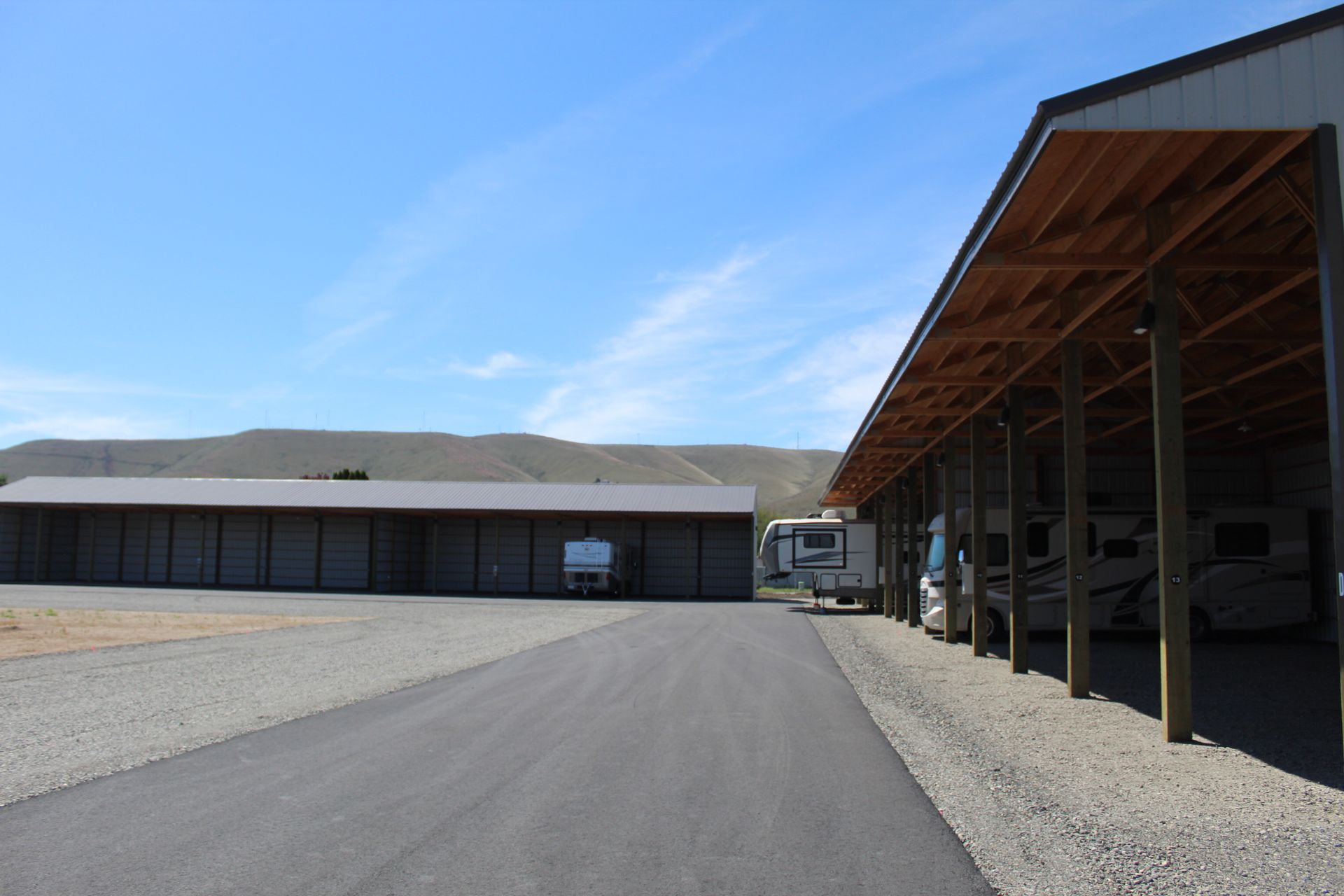 A row of rvs are parked under a covered area