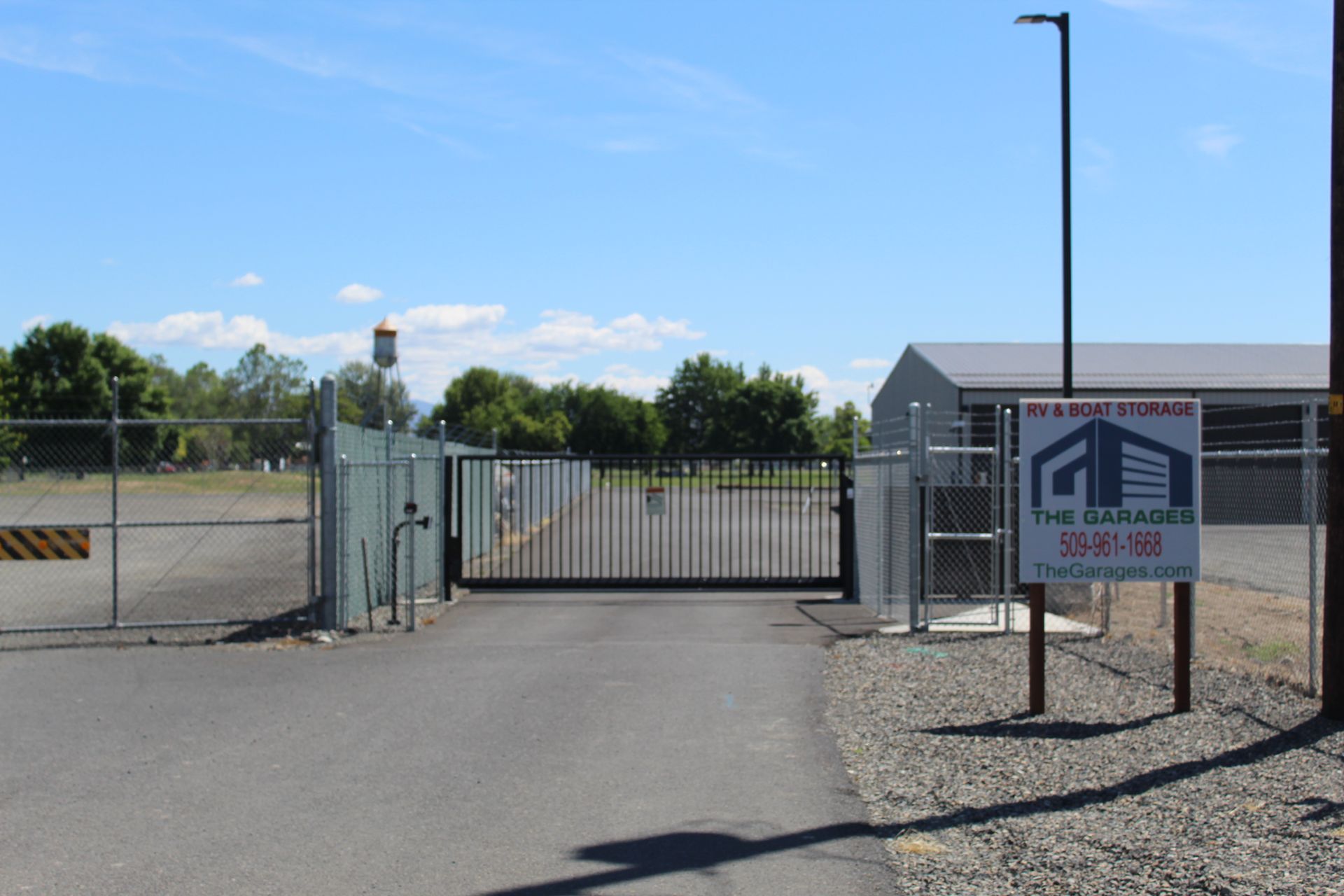 Entrance to a storage facility with gated access and a sign for 