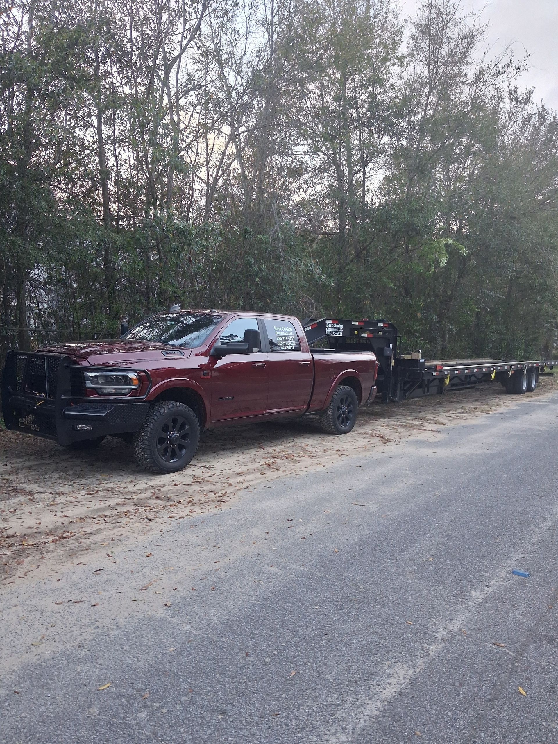 Two semi trucks are driving down a highway next to each other.