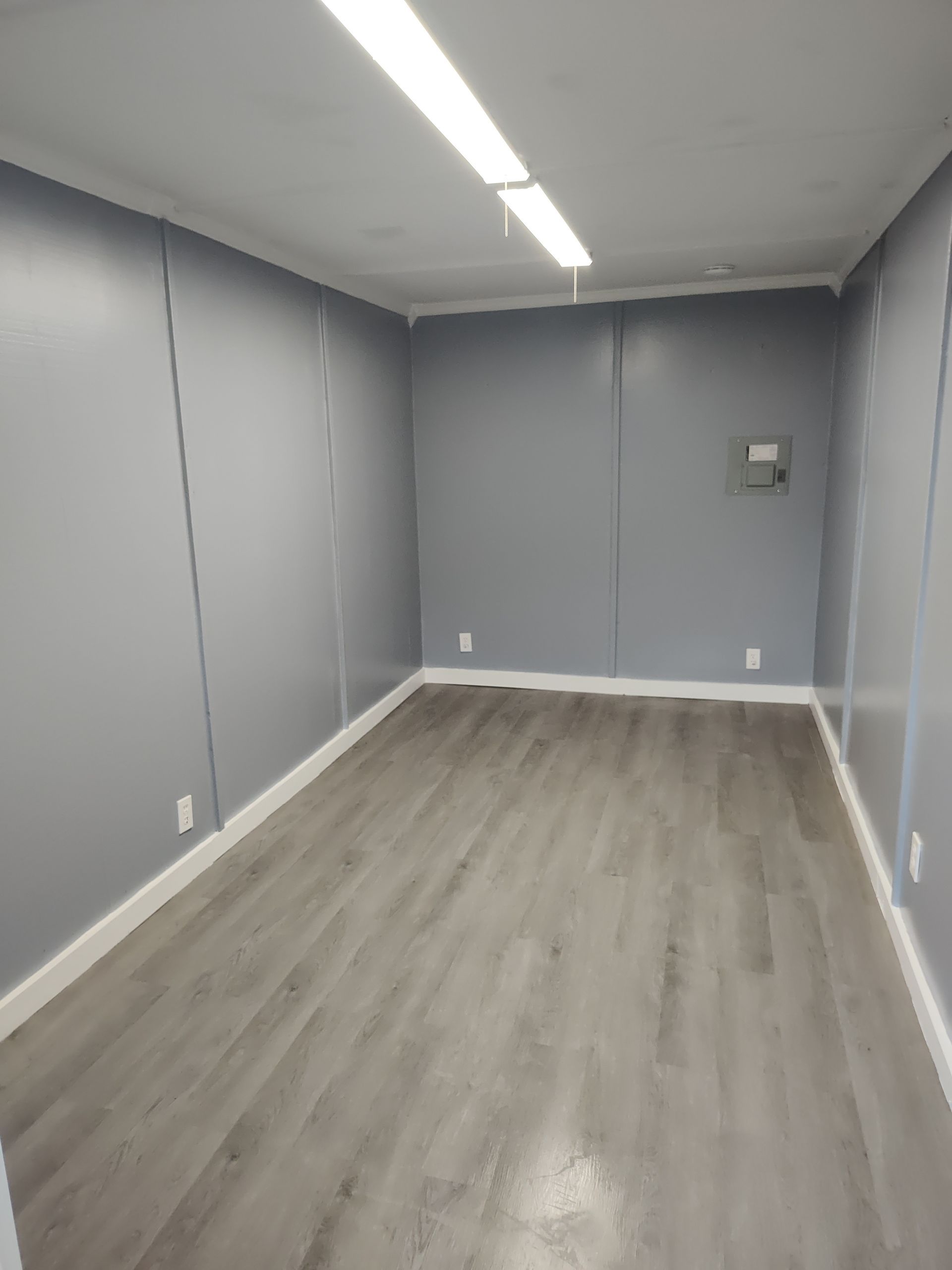 A man is welding a metal container with a welding mask on.