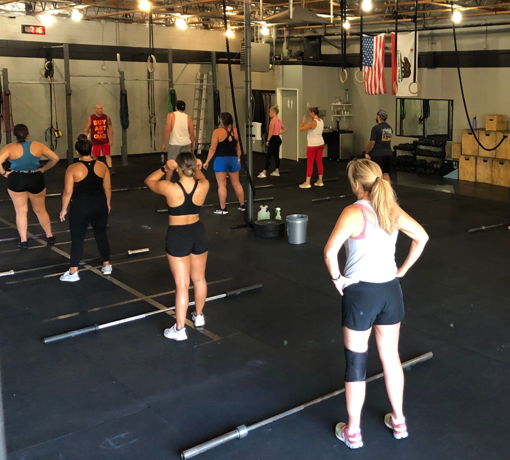A group of women are standing in a gym with one wearing a shirt with the number 13 on it