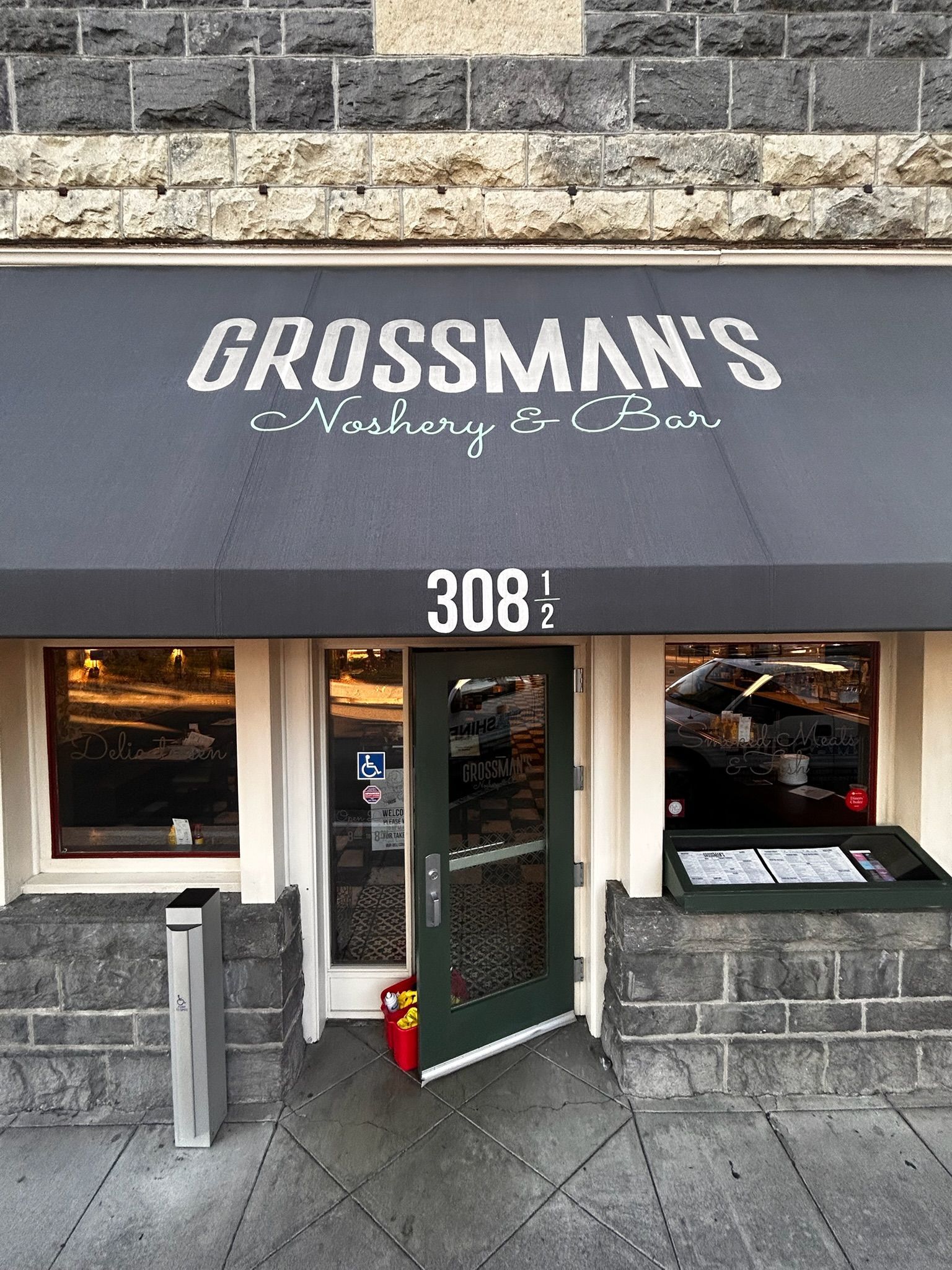 Grossman's, a restaurant, at 308 1/2, with a gray awning and stone facade.
