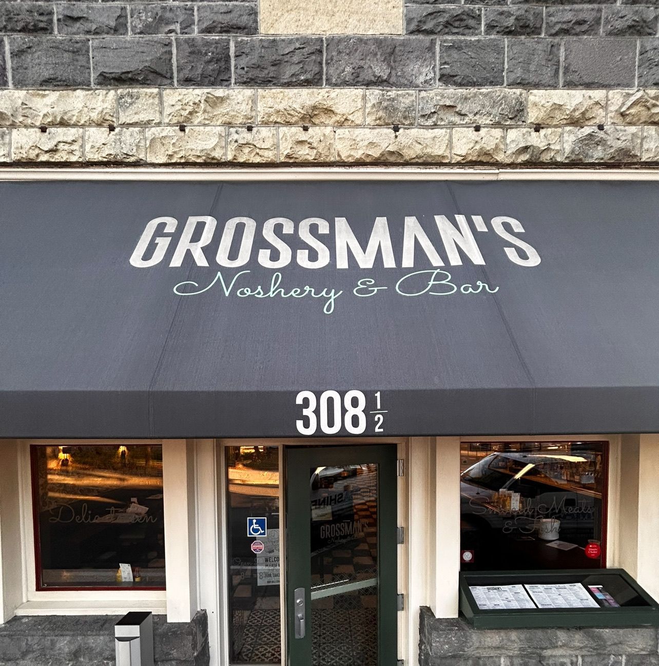 Grossman's Noshery & Bar storefront with a gray awning and brick exterior, at 308 1/2.