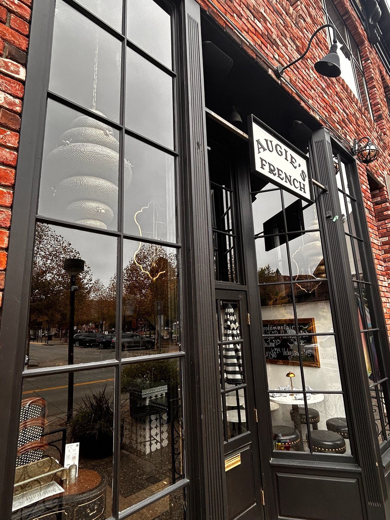 Brick building with black-framed windows and a sign reading 