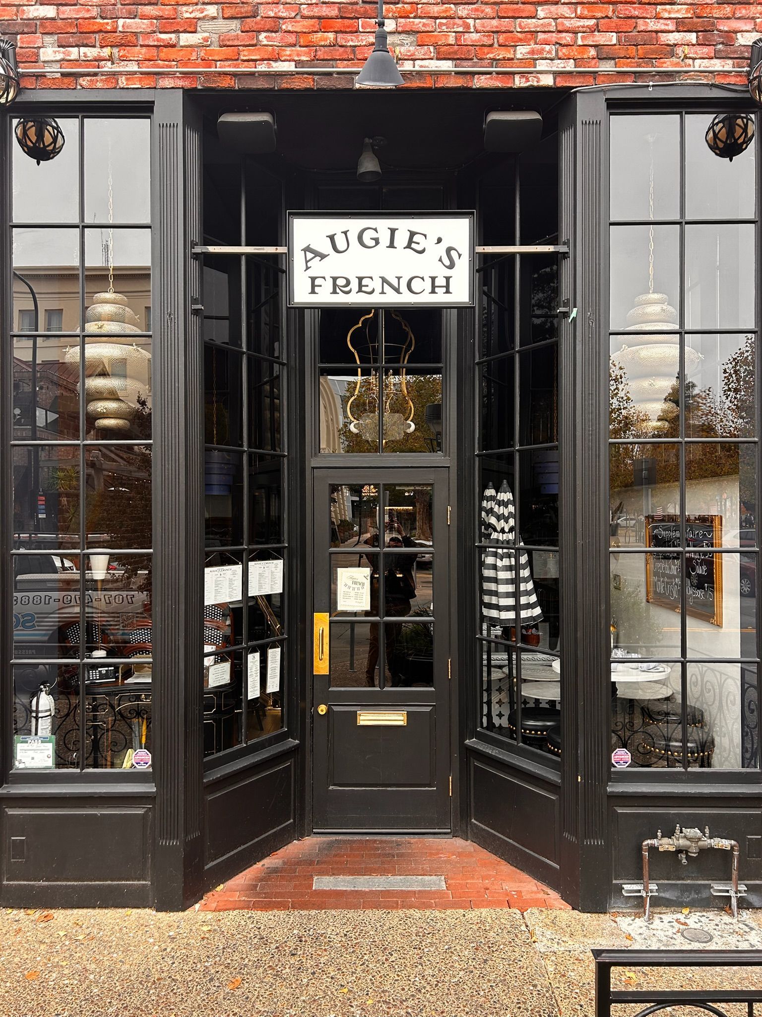 Black storefront with large windows; sign reads 