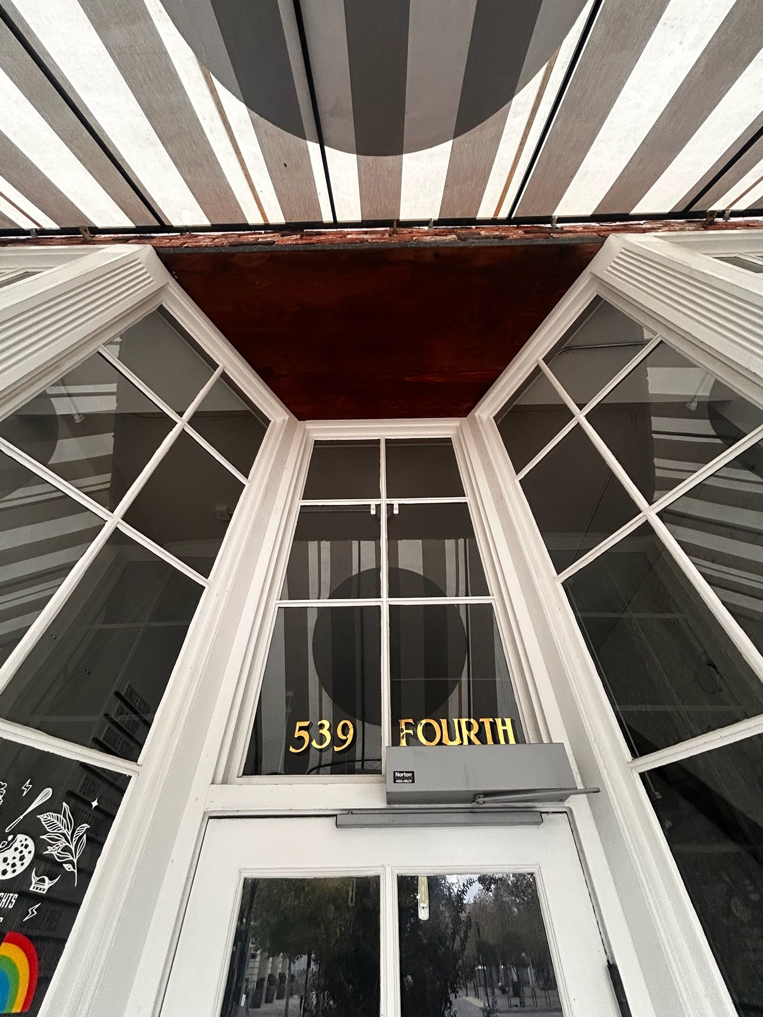 Building entrance with pyramid-shaped window frame, awning, and 