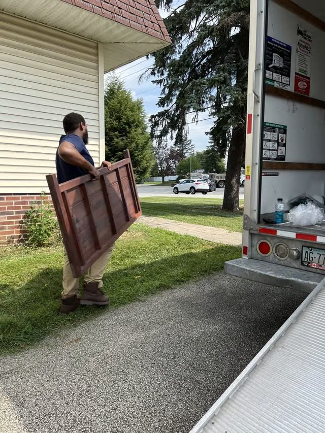 A man is carrying a wooden door into a truck.