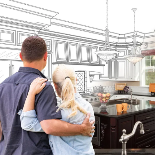 A man and woman hugging in front of a drawing of a kitchen