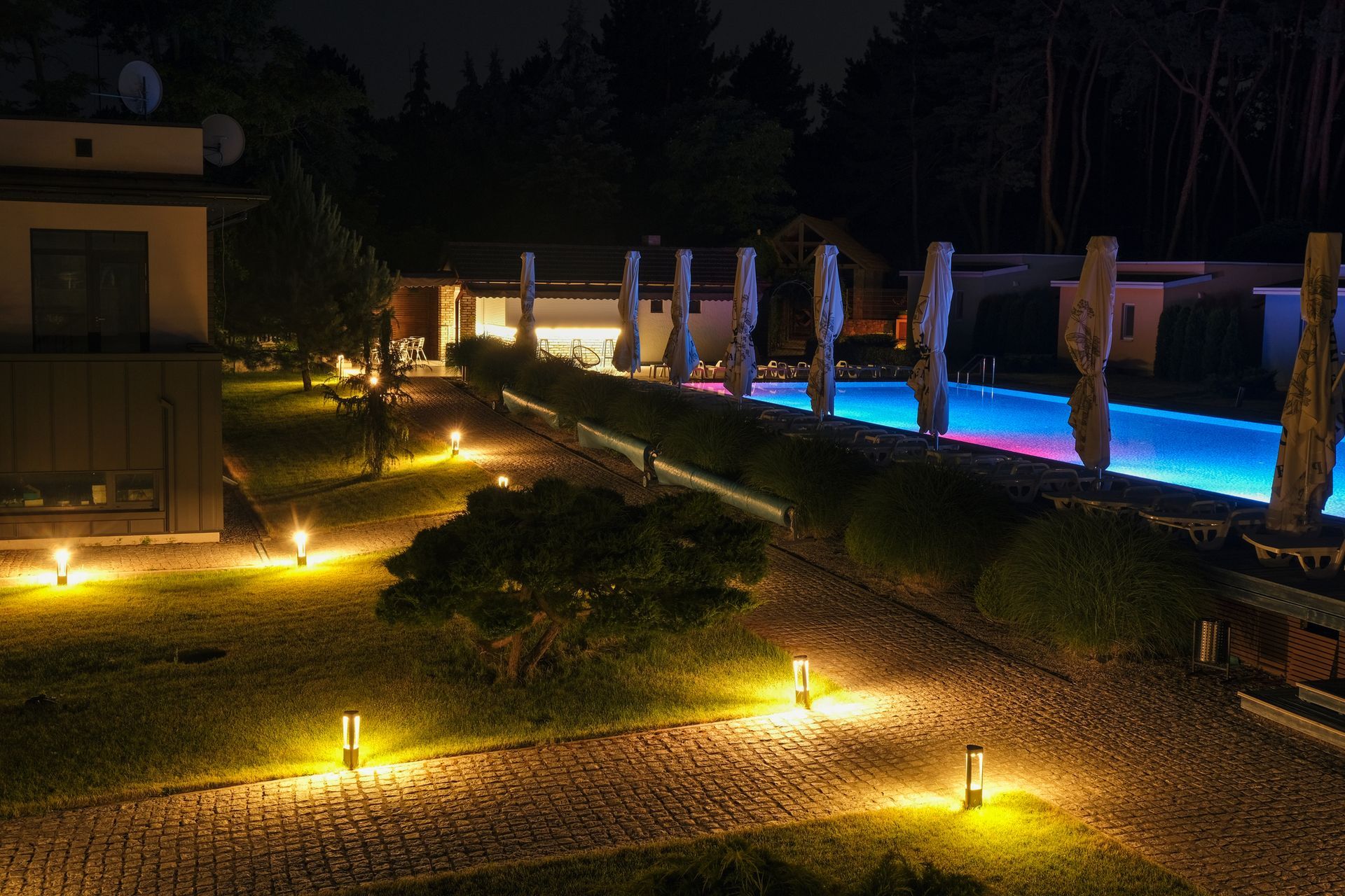 A large swimming pool is lit up at night.