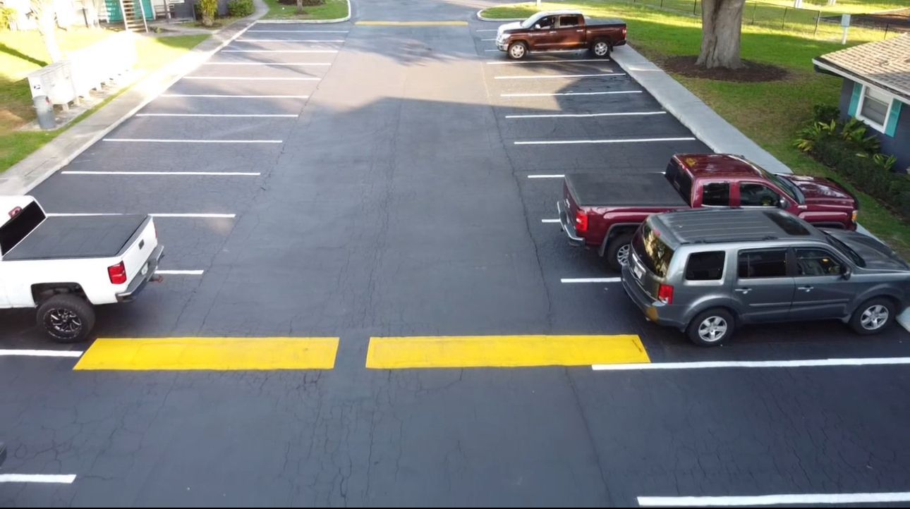 A man is laying bricks on a sidewalk.