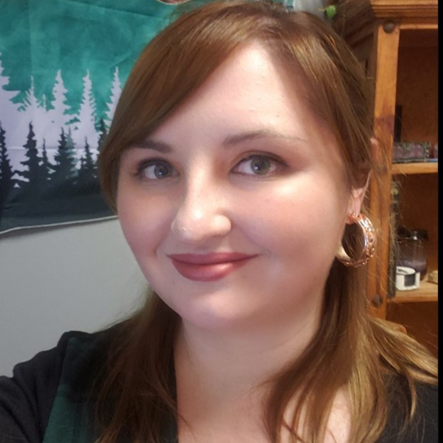 A close up of a woman 's face with a forest in the background