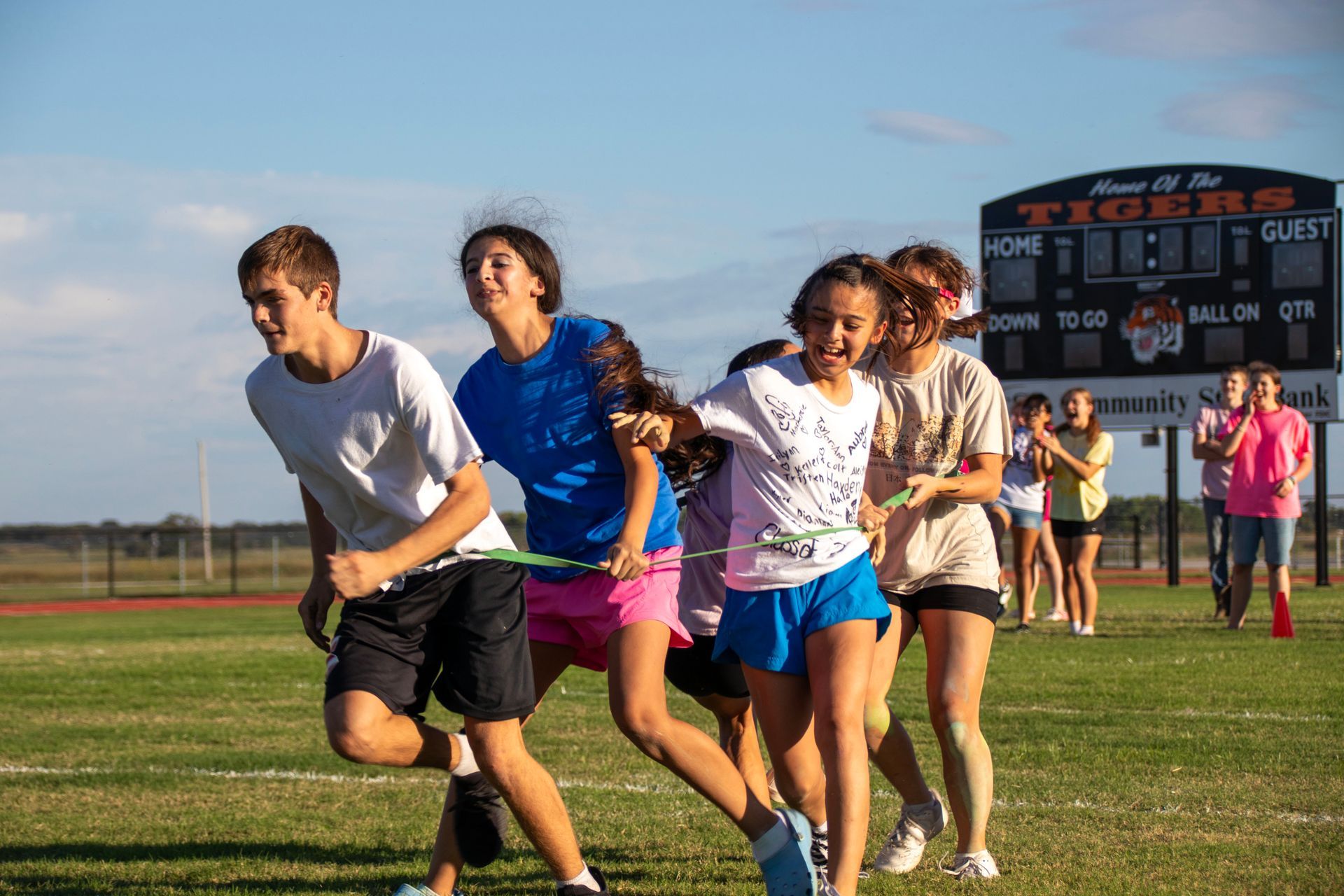 A group of young people are running on a field.