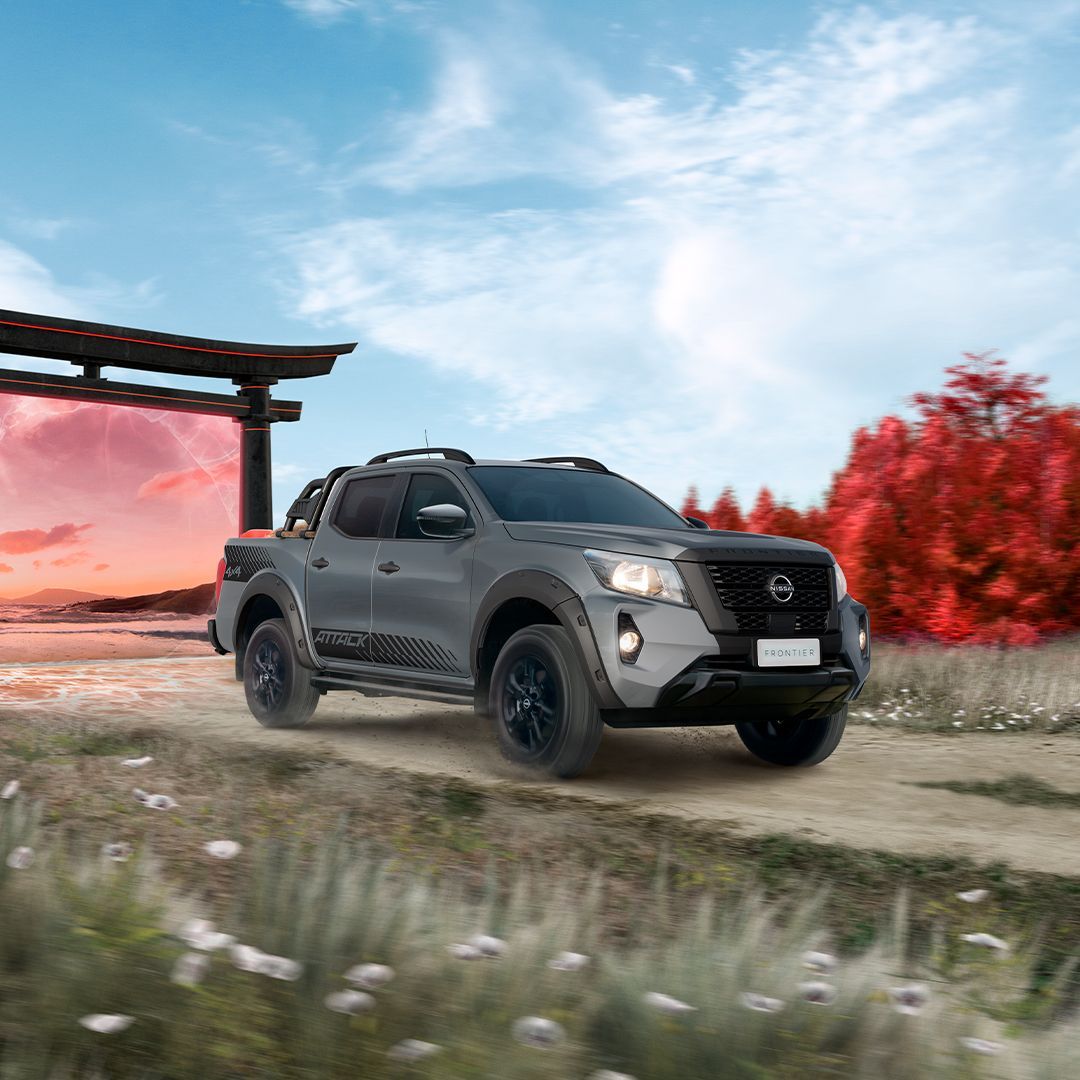 Uma caminhonete Nissan azul está dirigindo por uma estrada.