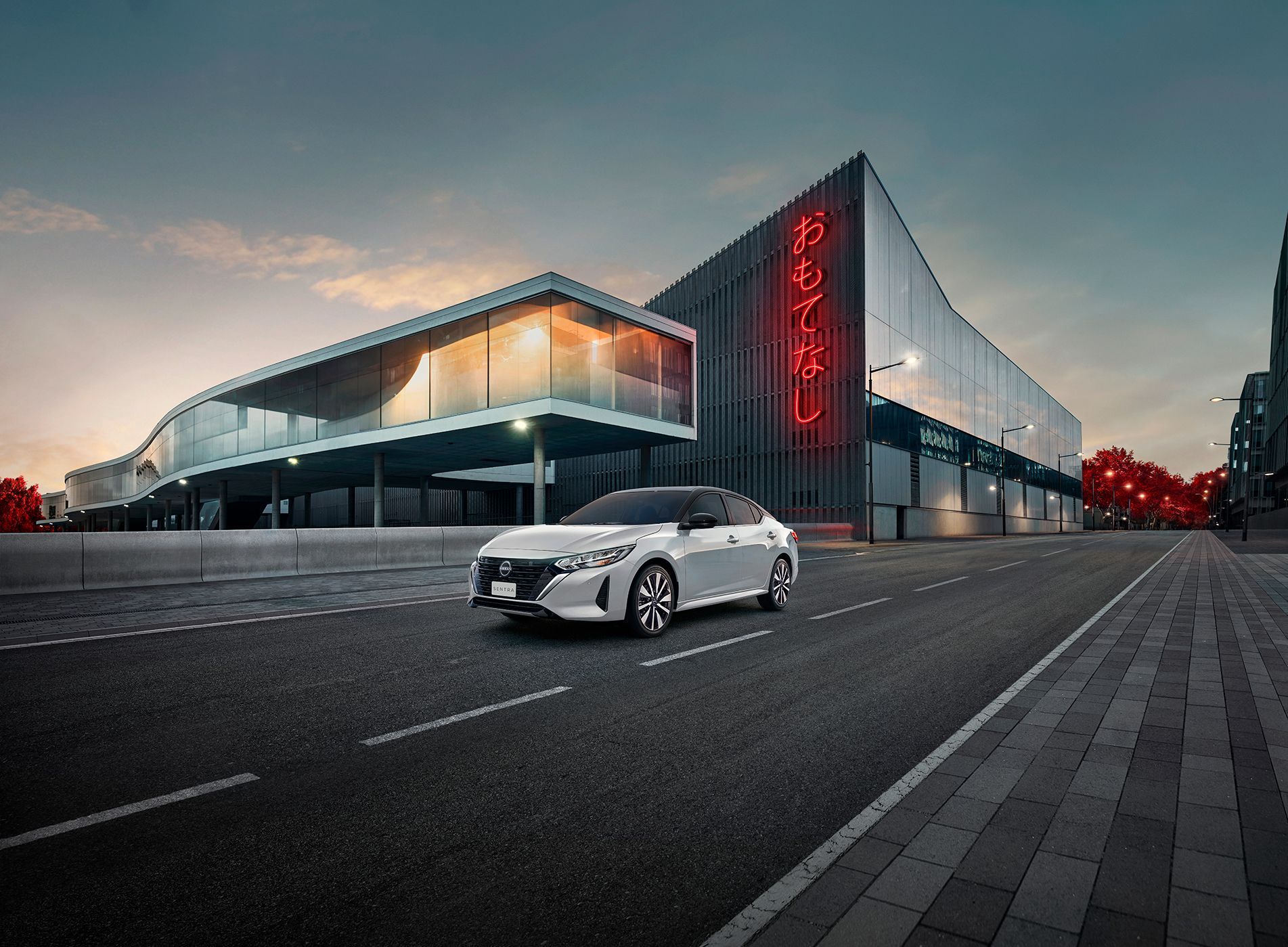 Um Nissan Kicks branco está dirigindo por uma estrada sinuosa.