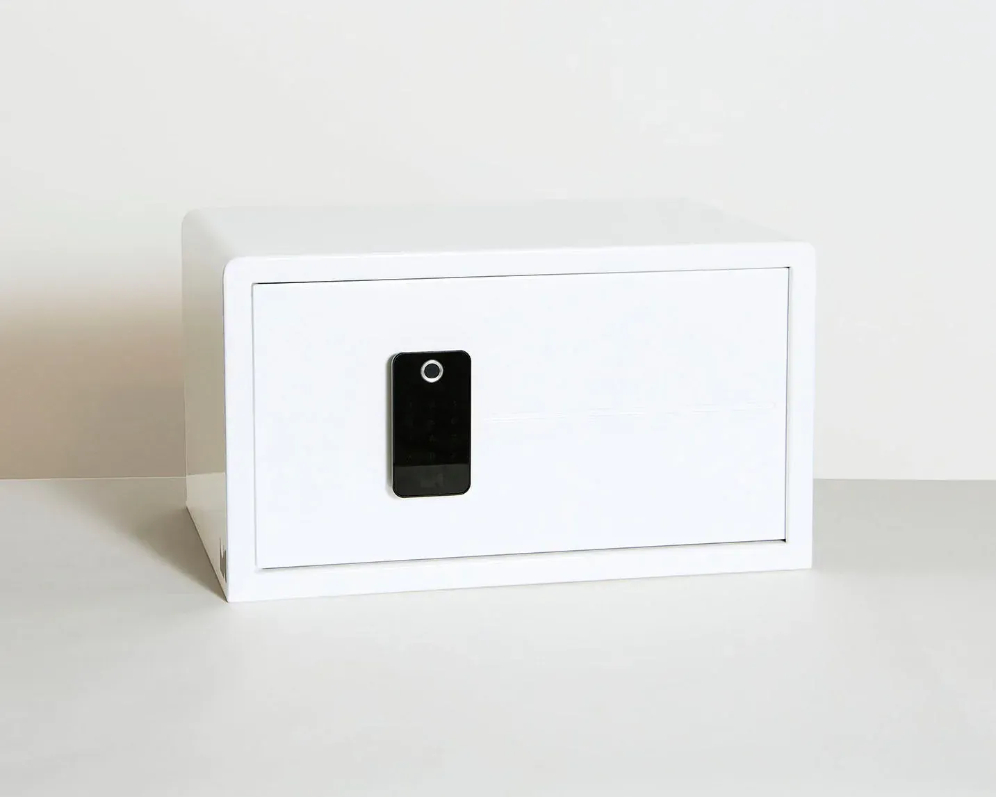 A white safe with a cell phone in it is sitting on a table.