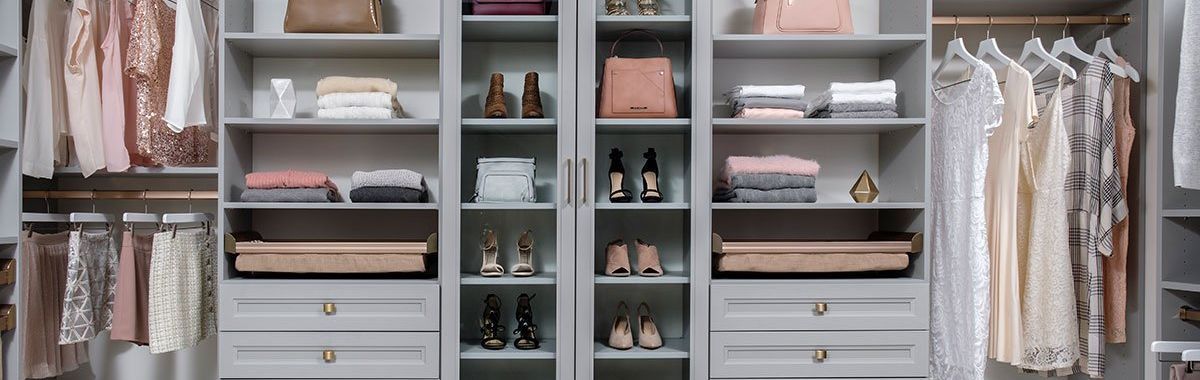 A walk in closet filled with lots of clothes and shoes.