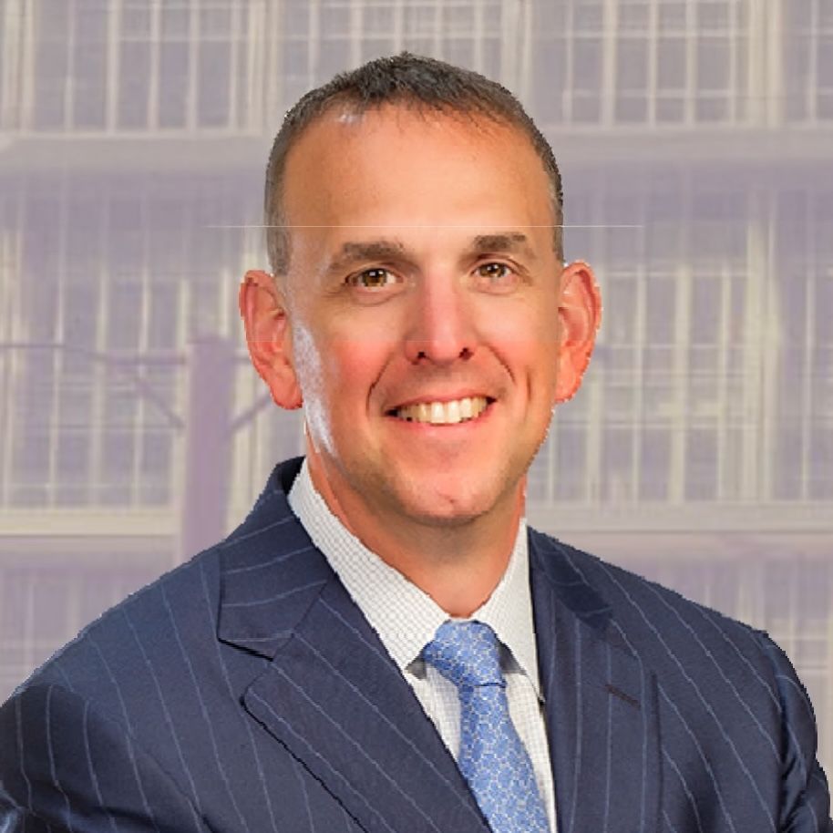 A professional headshot of a smiling person wearing a blue pinstriped suit and a light blue patterned tie.