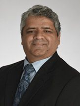 A man in a suit and tie is smiling for the camera.