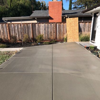 A concrete driveway is being built in front of a house.