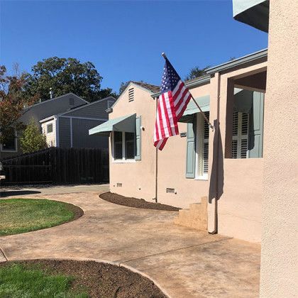An american flag is flying in front of a house
