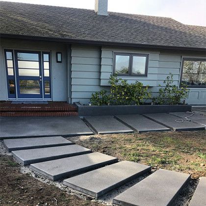 A house with a concrete walkway leading to the front door.
