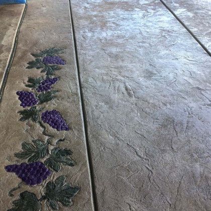 A concrete floor with grapes and leaves painted on it.