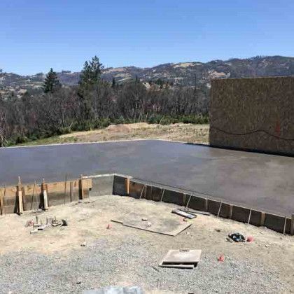 A concrete driveway is being built in the middle of a dirt field.