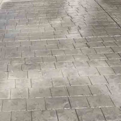 A close up of a brick pavement with a diagonal pattern.