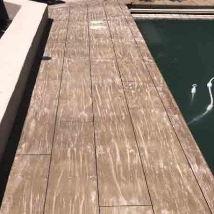 A wooden deck next to a swimming pool.