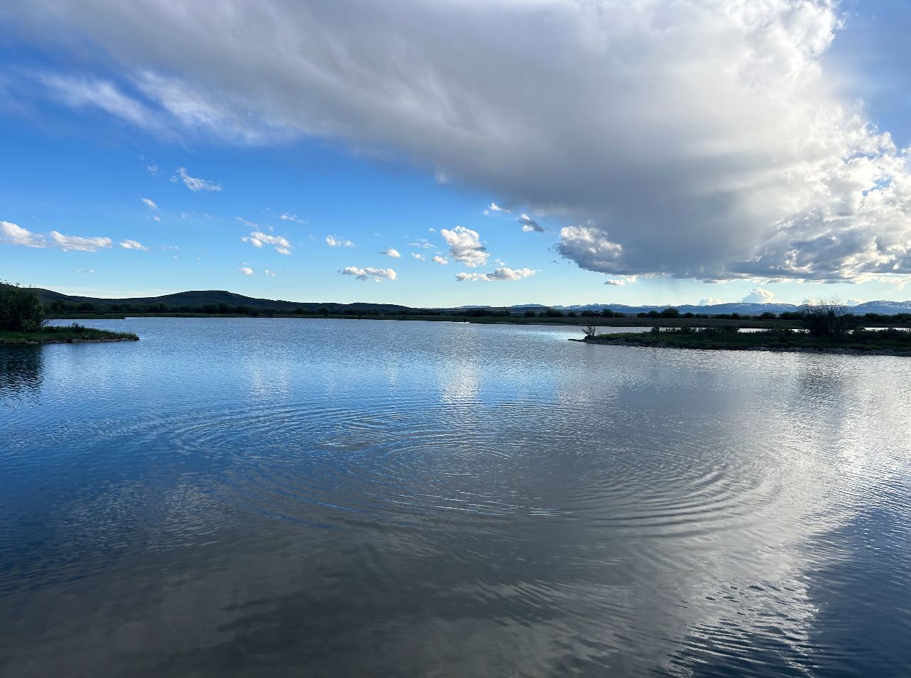 A large body of water with a cloudy sky in the background.