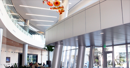 Modern lobby with curved walls, glass windows, and decorative art.