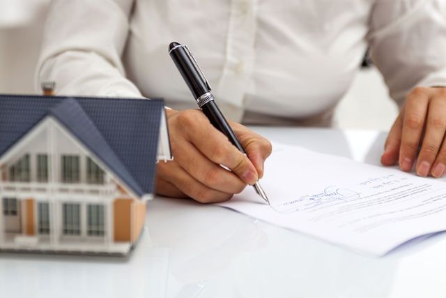 Photo of Person Signing a Rental Agreement