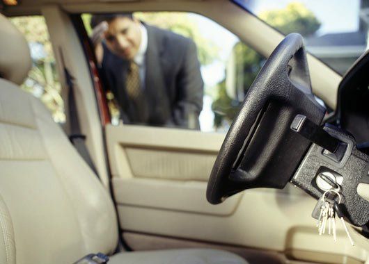 A man in a suit is looking through the window of a car