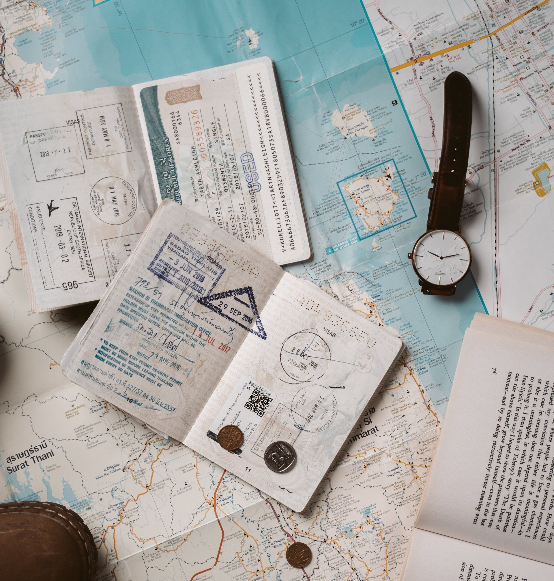 A passport , a watch , and a map are on a table.