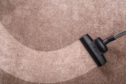 Vacuuming carpet with vacuum cleaner