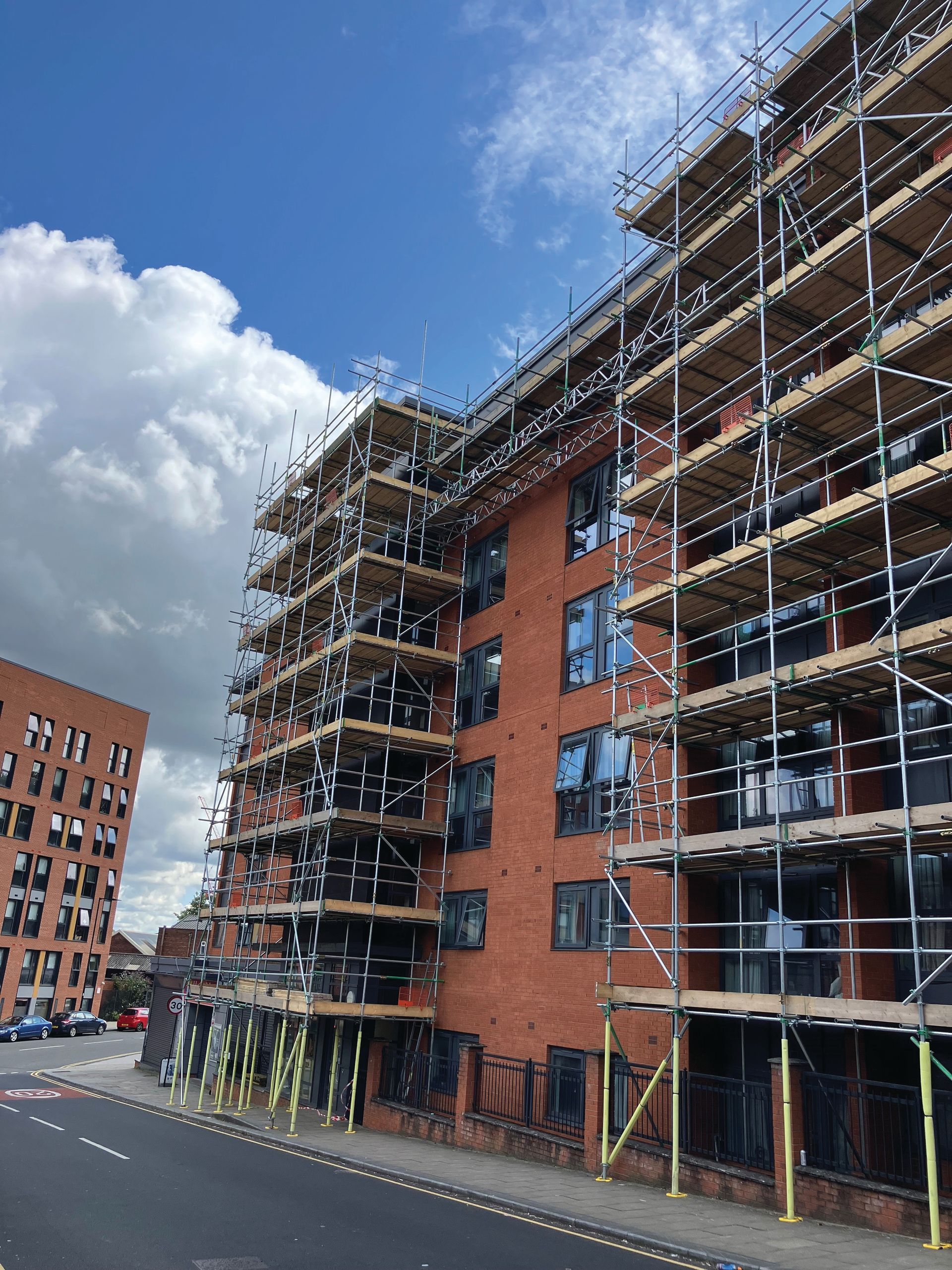 A large brick building is being built with scaffolding around it.