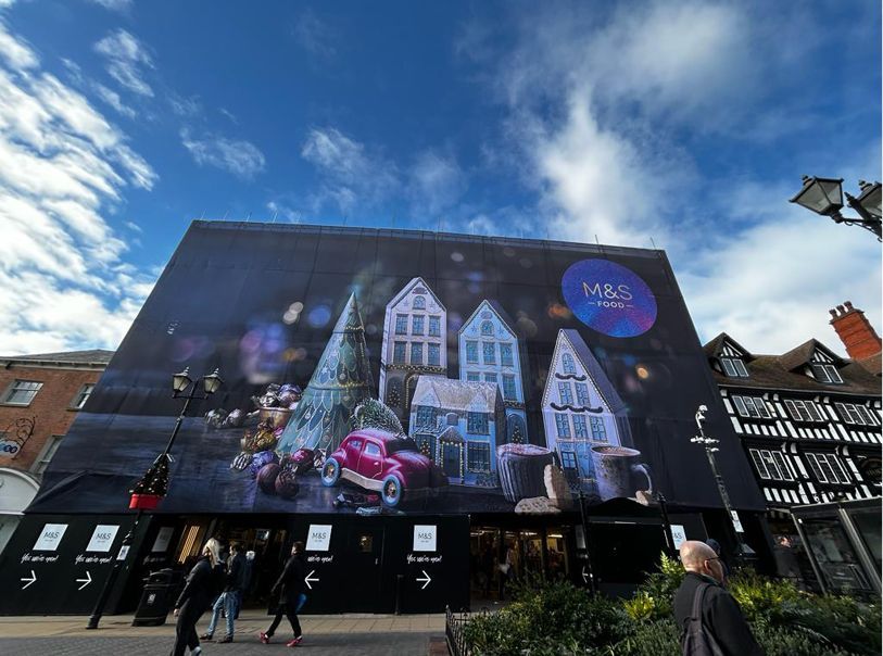 A large billboard is hanging on the side of a building.