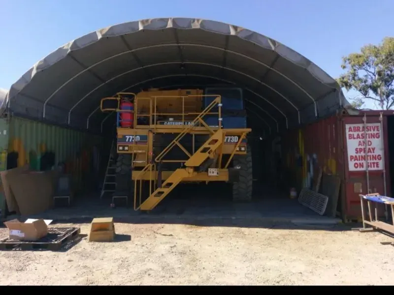 Yellow Industrial Vehicle Inside a Large Arched Shelter — All Blast and Paint in Paget, QLD