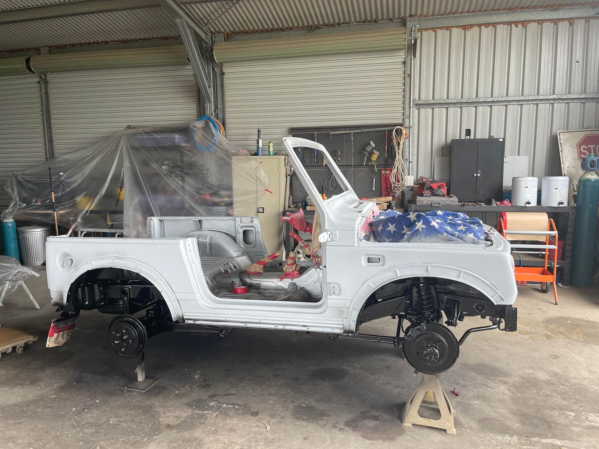White Suzuki Samurai Body on Jack Stands in a Garage — All Blast and Paint in Marian, QLD