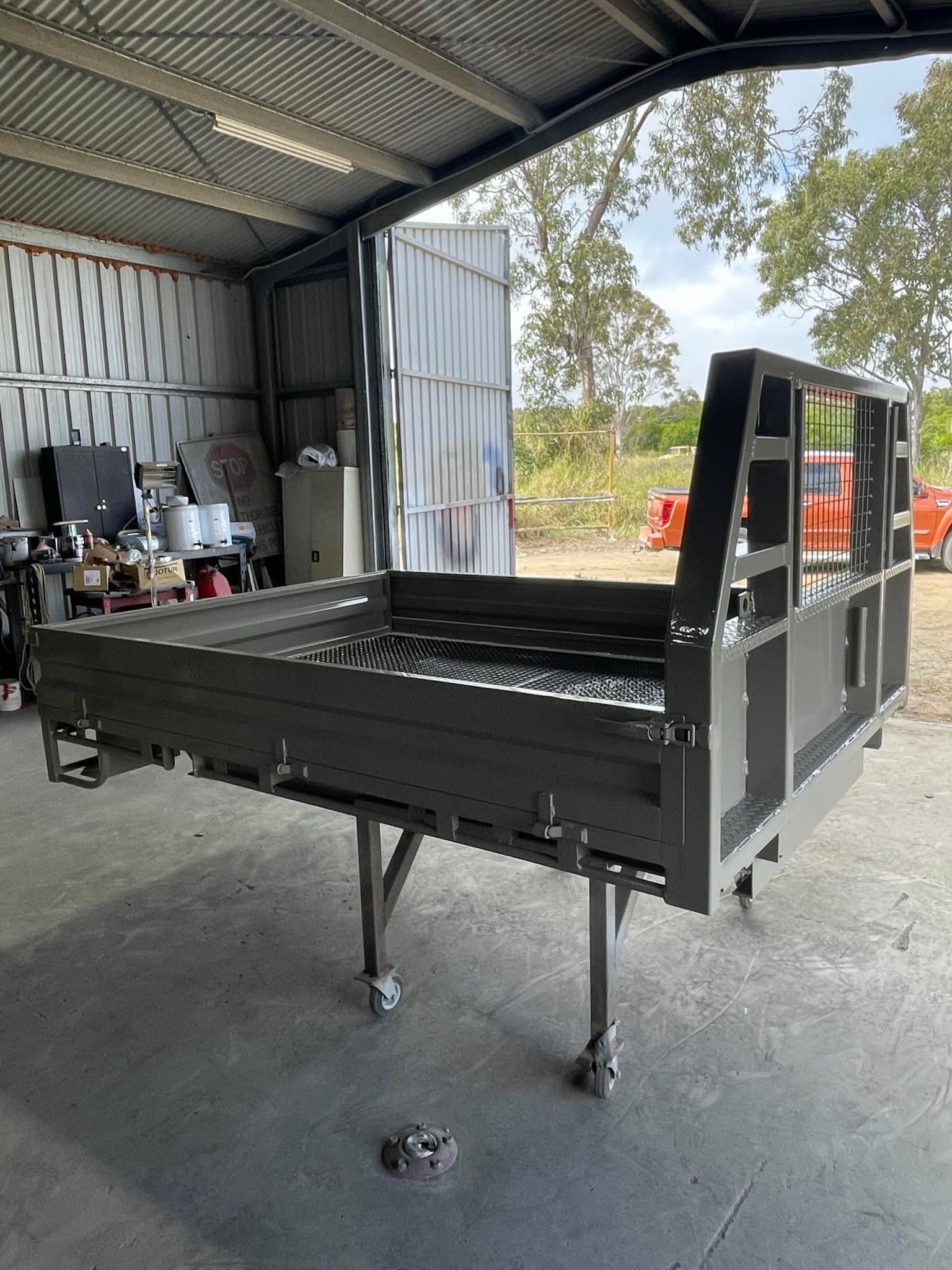 A Metal Truck Bed Frame Sits on a Rolling Stand Inside a Workshop — All Blast and Paint in Marian, QLD