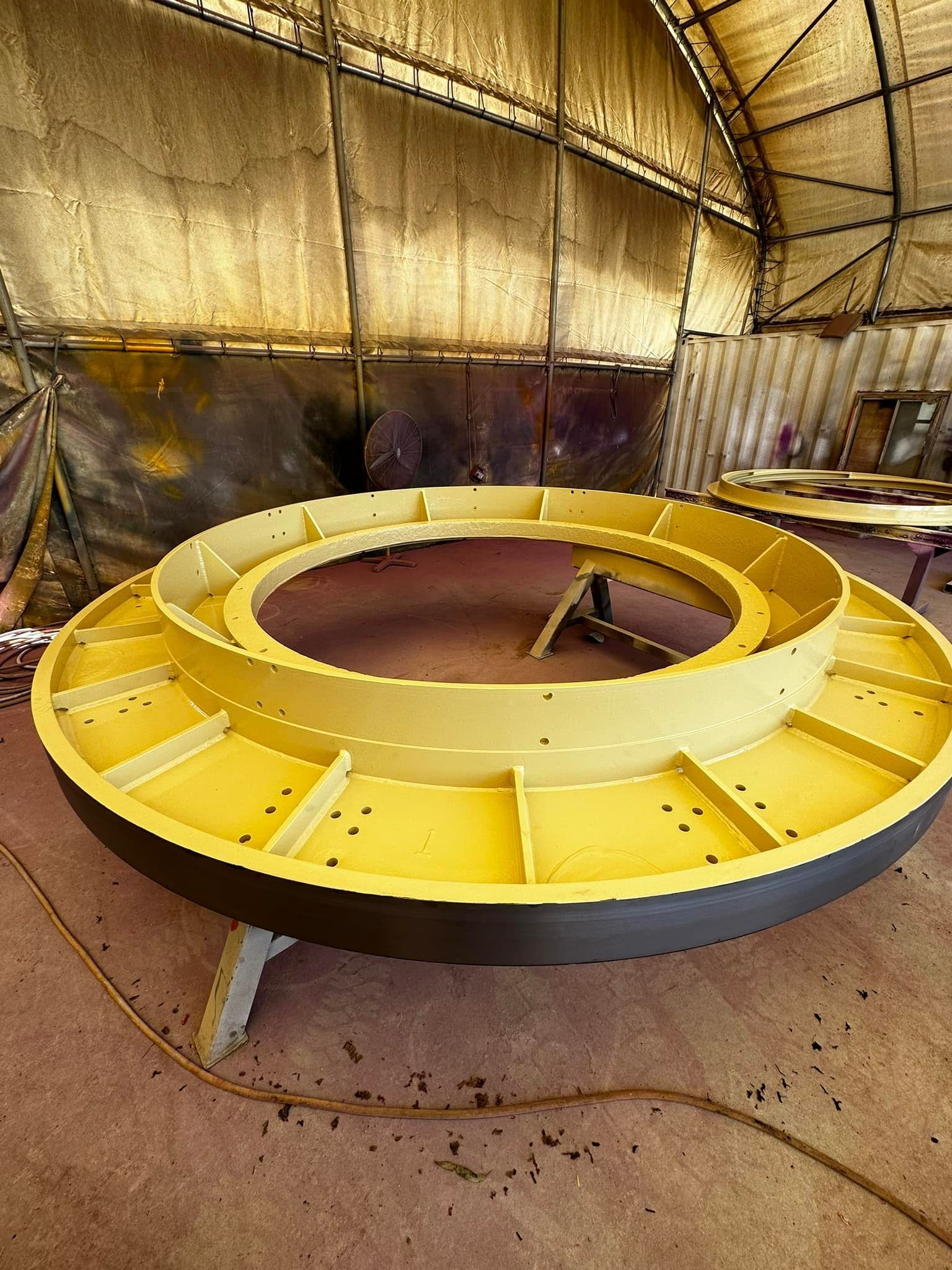 Yellow Circular Platform With Dark Gray Rim in a Workshop — All Blast and Paint in Bakers Creek, QLD