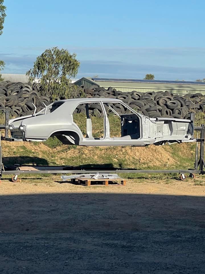 A Car Body Shell, Painted Gray, is on a Lift Outdoors — All Blast and Paint in Paget, QLD
