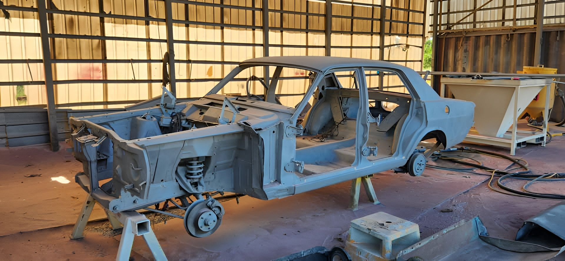 A Stripped-down Classic Car on Stands Inside a Workshop — All Blast and Paint in Bakers Creek, QLD