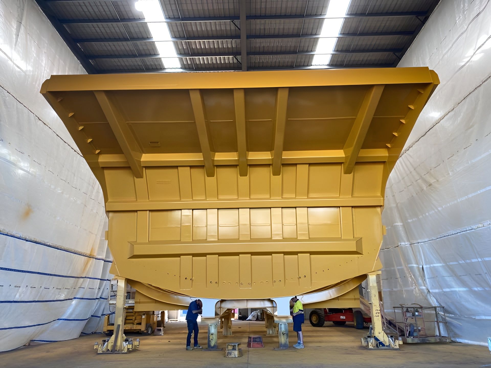 Yellow Mining Truck Body on Supports Inside a Warehouse — All Blast and Paint in Bakers Creek, QLD