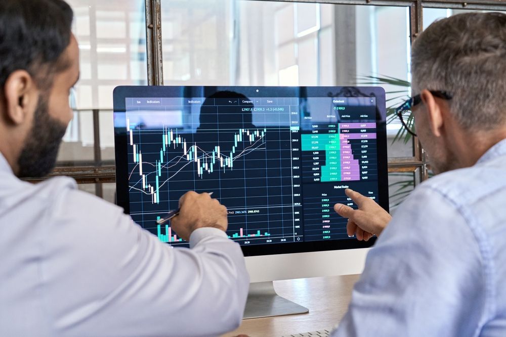 two financial consultants looking at financial data on a computer screen to help support sellers through due diligence 