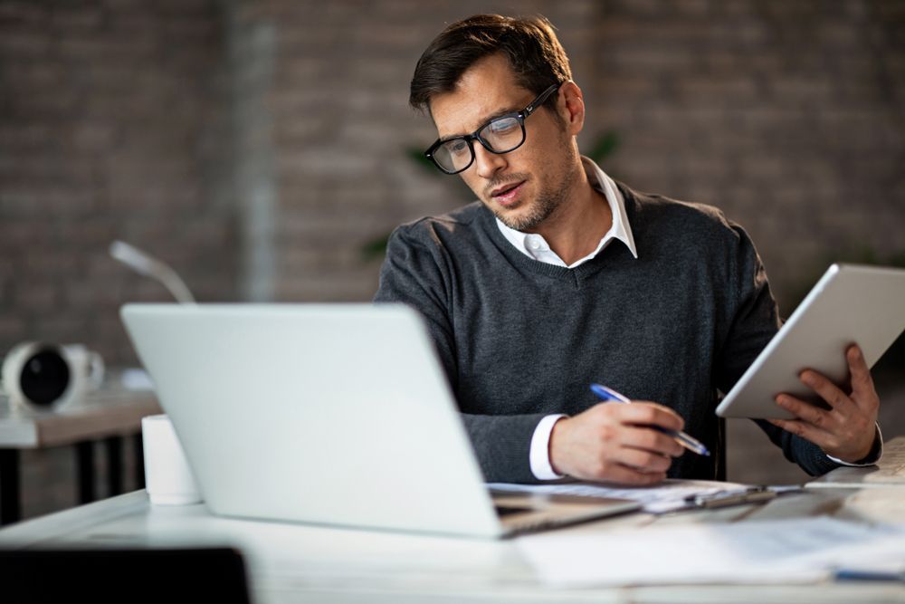 SaaS business owner looking on laptop, considering an exit strategy