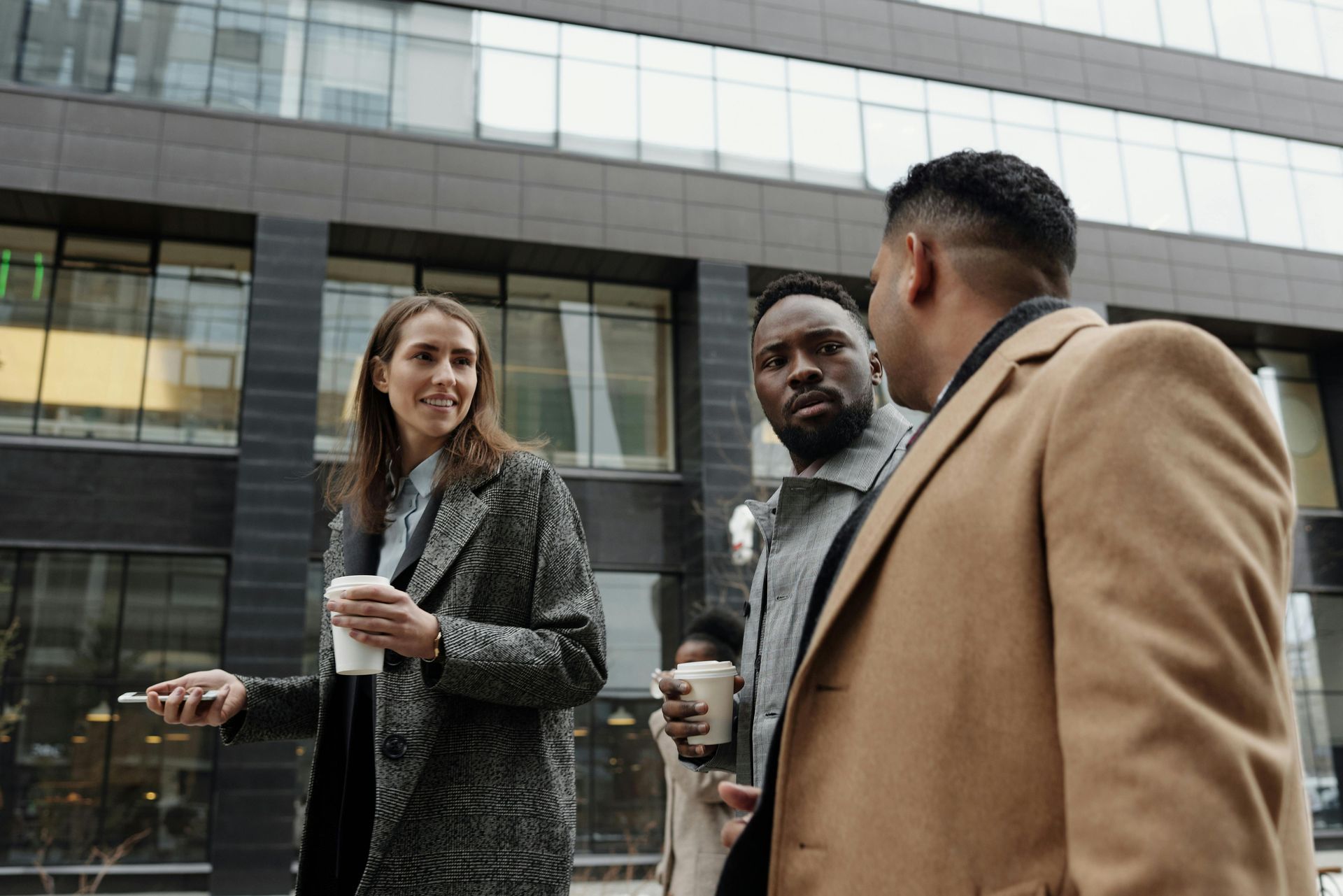 Professionals discussing fintech risk and compliance outside an office building.