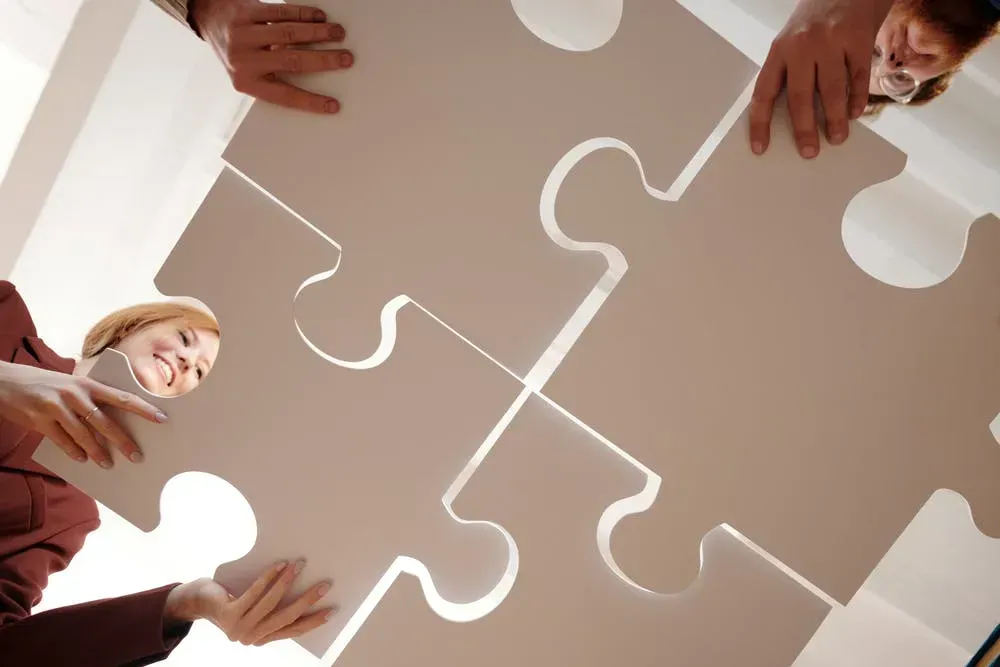 A group of people are putting together a large puzzle piece