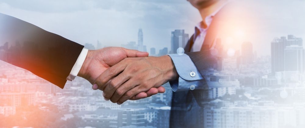 Two people shaking hands, business deal, city background.