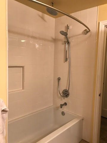 A bathtub with a shower head attached to it in a bathroom.